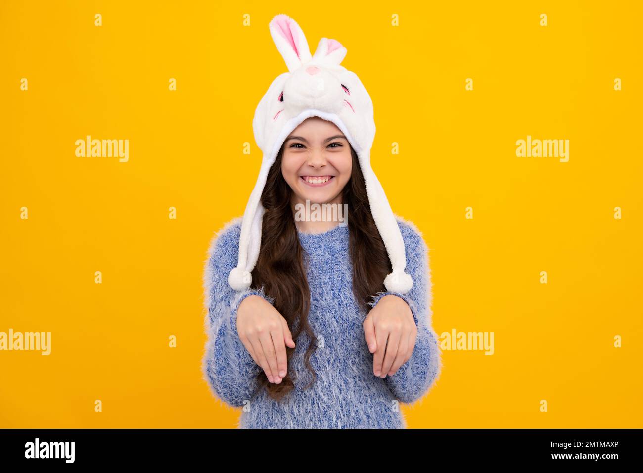 Chapeau d'hiver lapin. Concept de saison froide. Accessoire mode hiver pour enfants. Jeune fille portant un chapeau tricoté chaud. Visage amusant. Banque D'Images