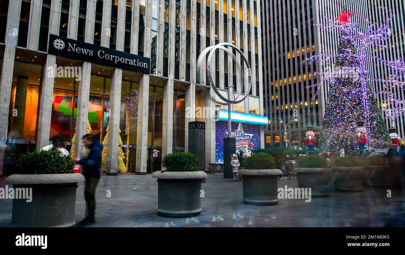 NEW YORK, NY, Etats-Unis - 10 DÉCEMBRE 2022: Magnifique arbre de Noël à 6th AV près de News Corporation bâtiment avec des gens flous marchant autour Banque D'Images