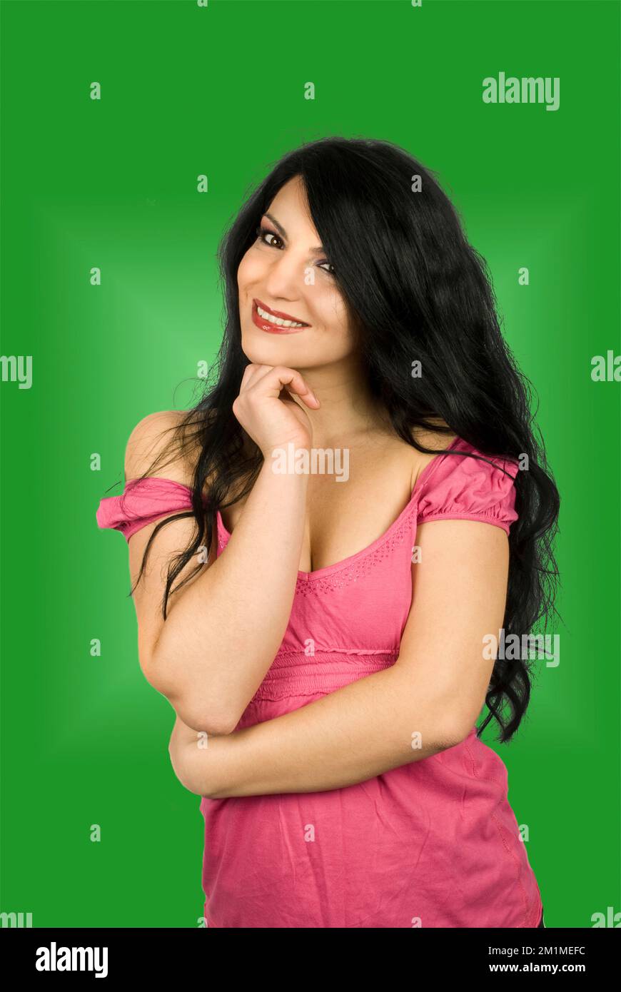 Belle jeune femme brune souriante et debout avec la main au menton isolée sur fond blanc Banque D'Images