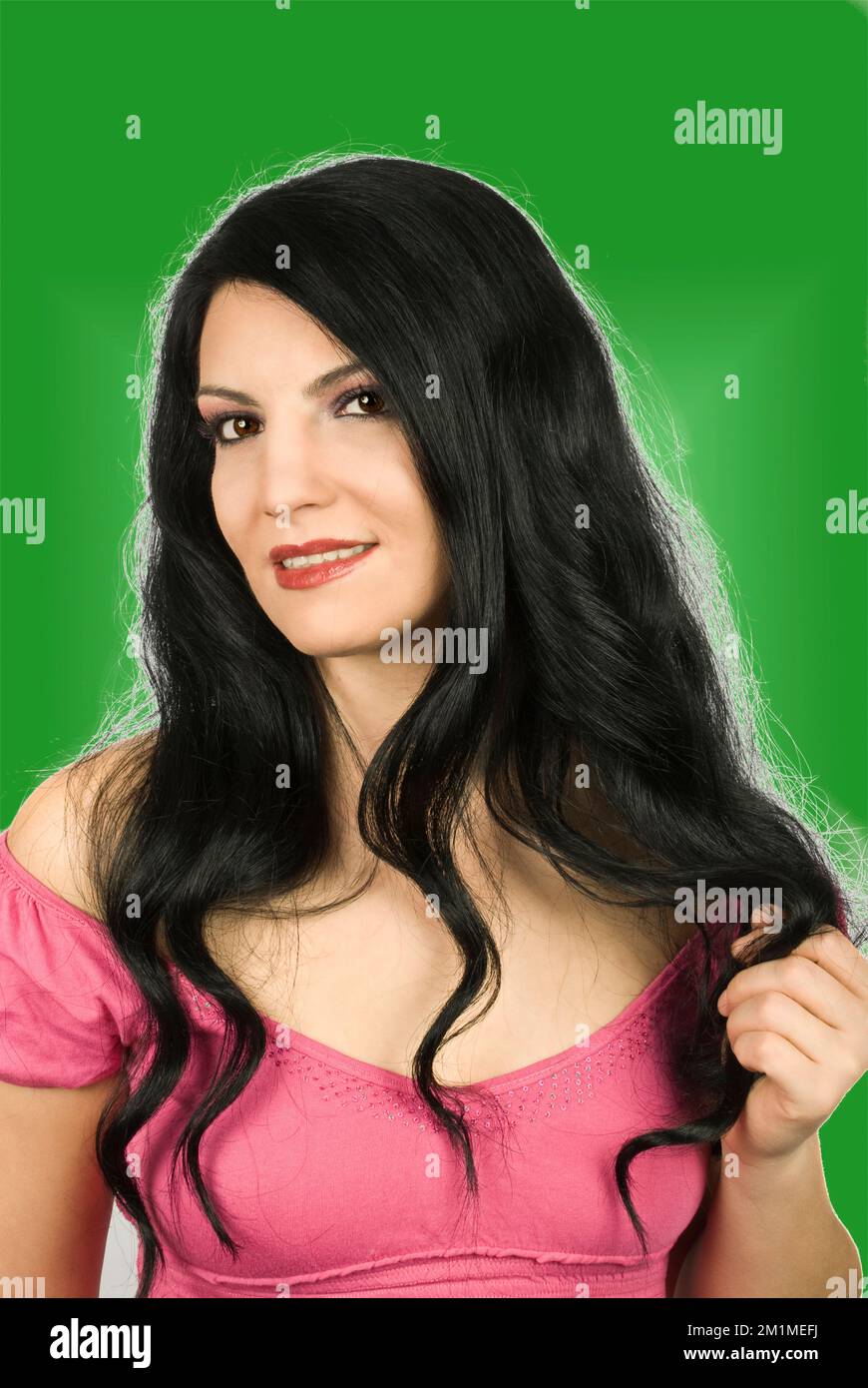 Belle femme avec de longs cheveux brillants noirs souriant et vous regardant isolé sur fond blanc Banque D'Images