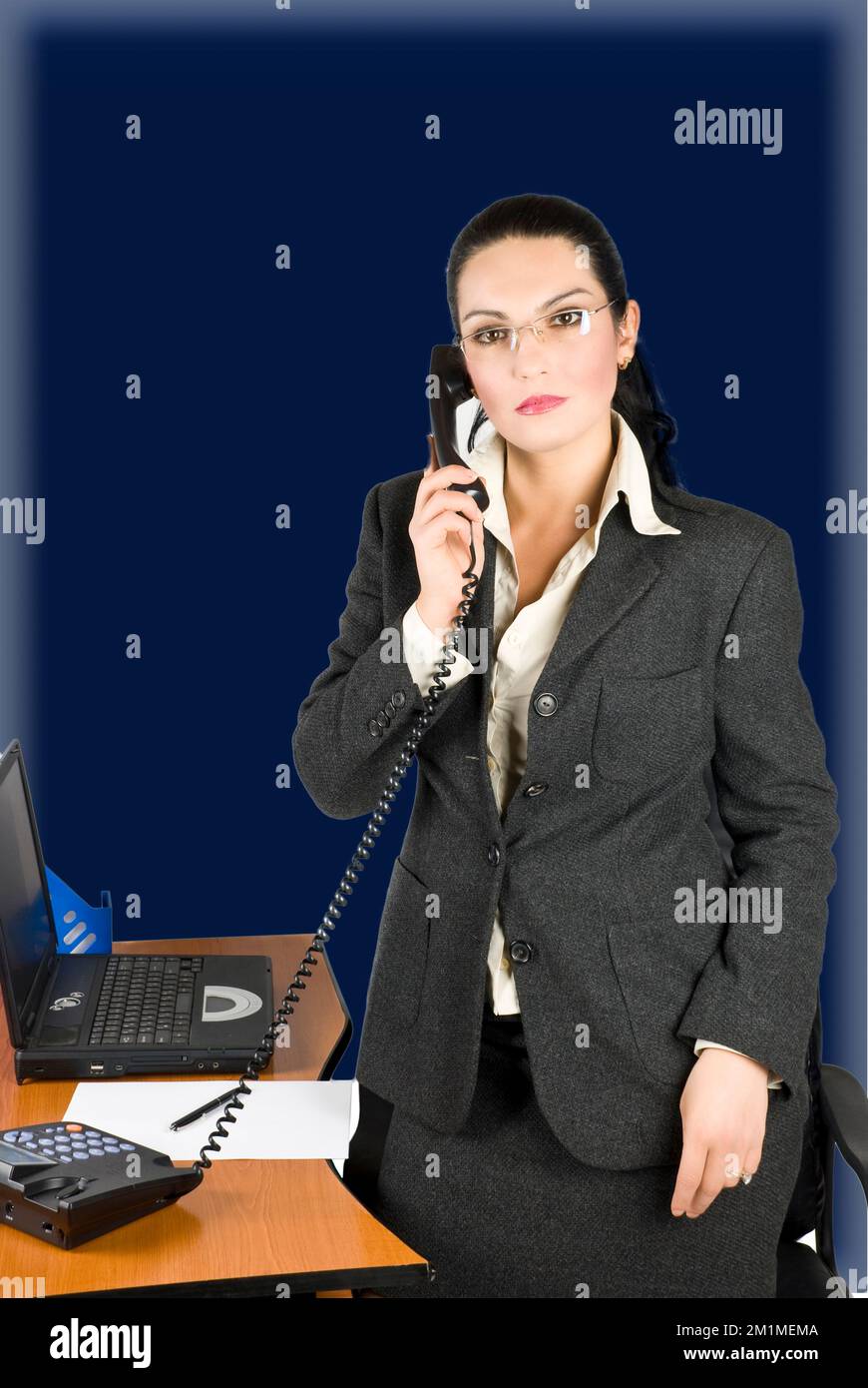 Femme d'affaires avec téléphone à son bureau Banque D'Images