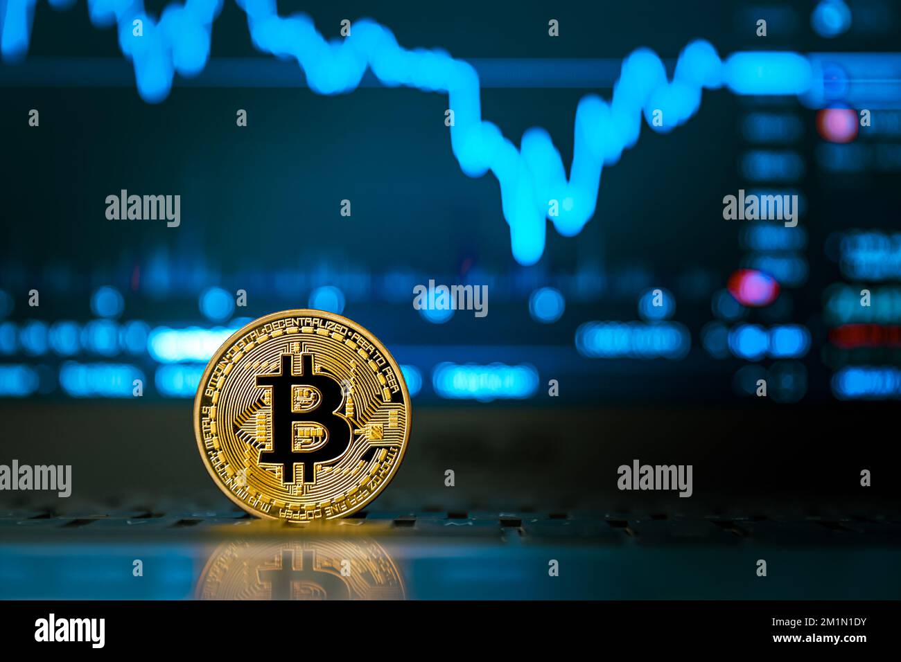 pièce de monnaie en or bitcoin et écran avec graphiques financiers Banque D'Images