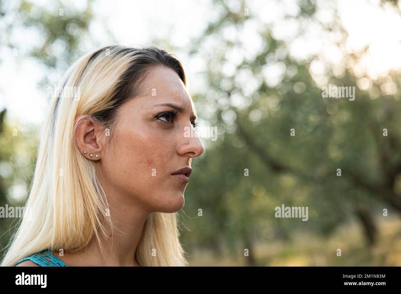 Un foyer sélectif d'une blonde face à côté avec une expression sérieuse dans un parc en Italie Banque D'Images