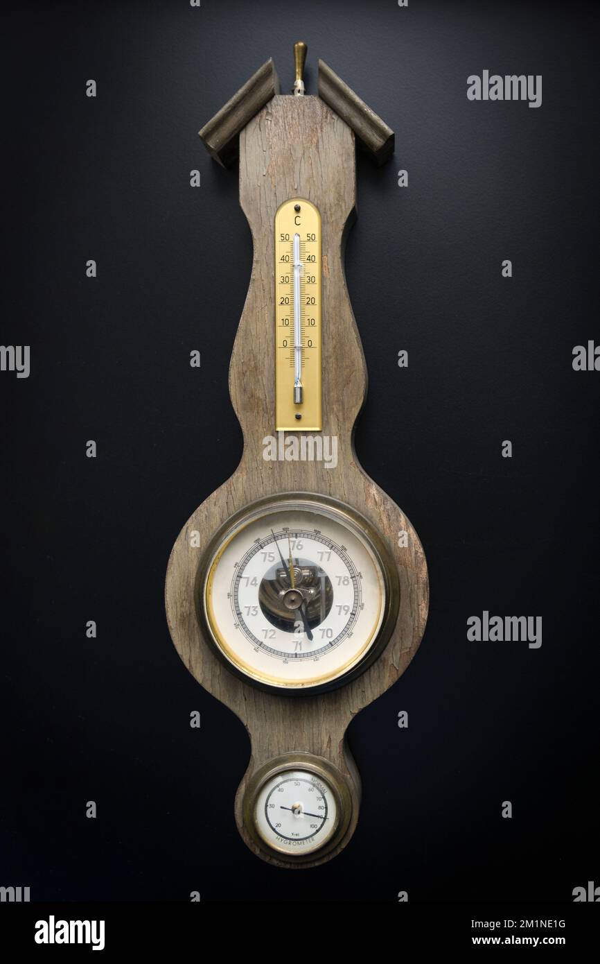 Ancien baromètre mural avec hygromètre et thermomètre intégrés. Arrière-plan noir Banque D'Images