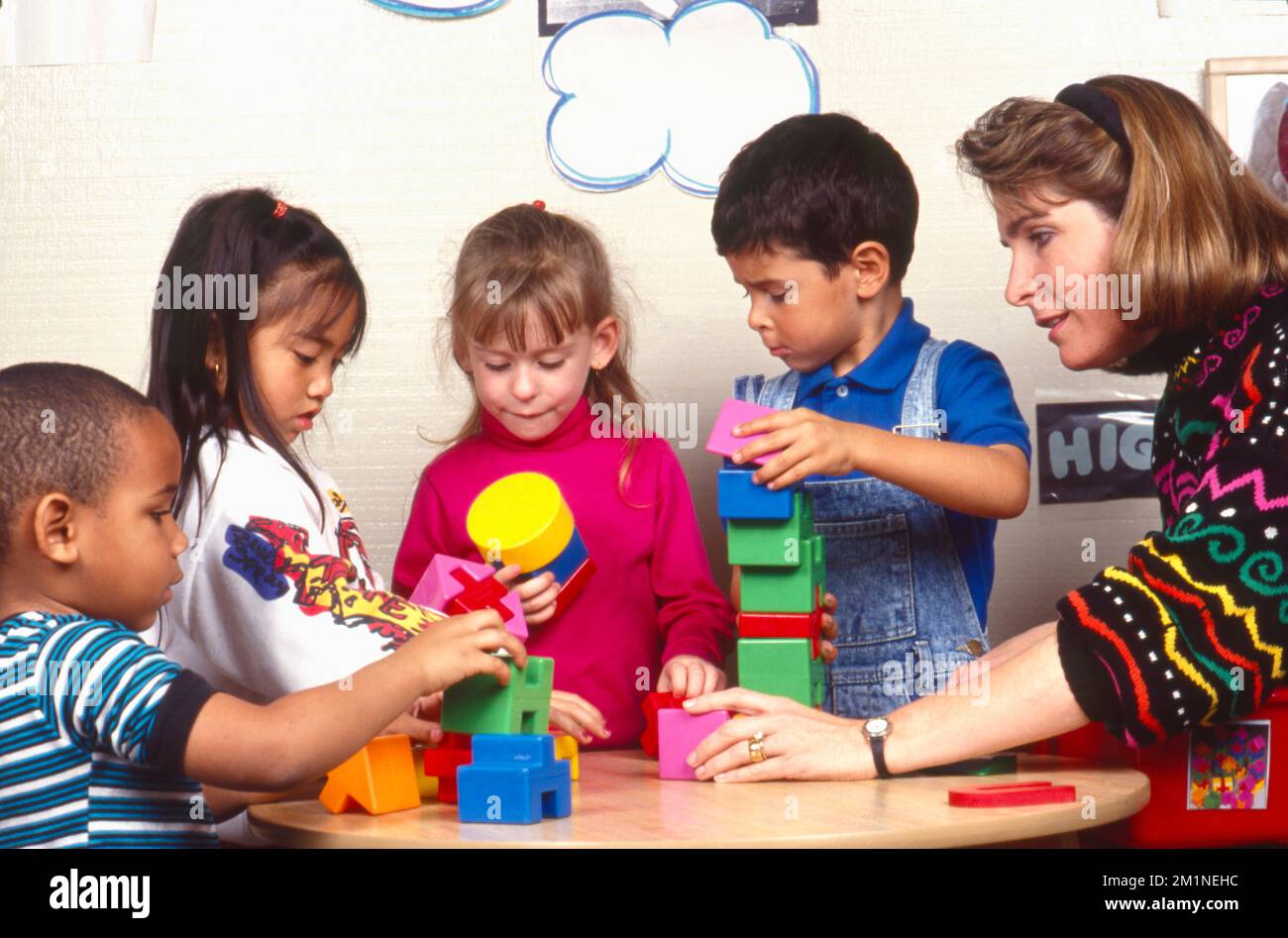 Professeur d'école avec des enfants bâtiment avec des jouets de bloc de construction Banque D'Images