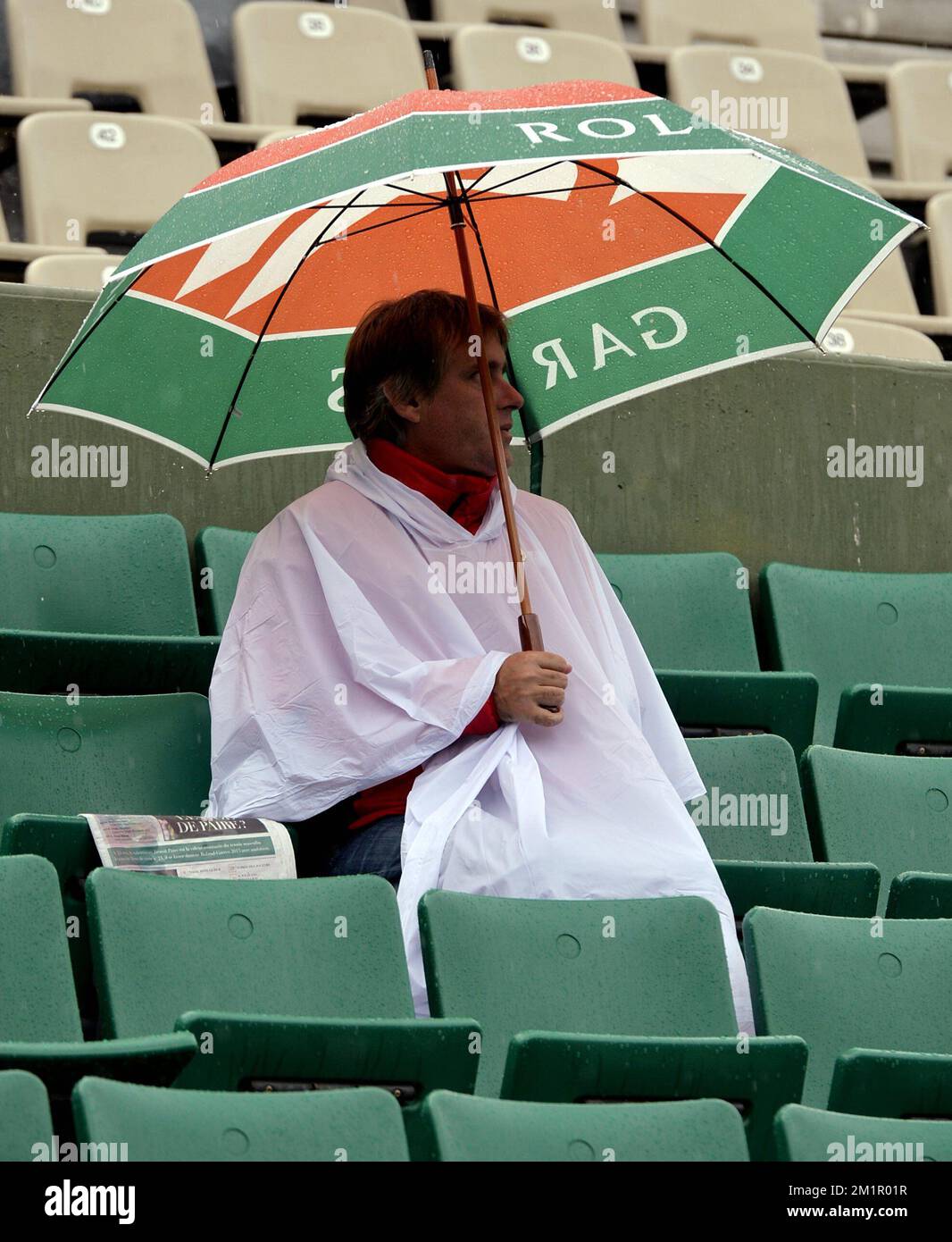 20130528 - PARIS, FRANCE: L'illustration montre un homme avec un parapluie  comme il pleut et les jeux ont été reportés au tournoi Roland Garros 2013,  ouvert au tennis français, au stade Roland