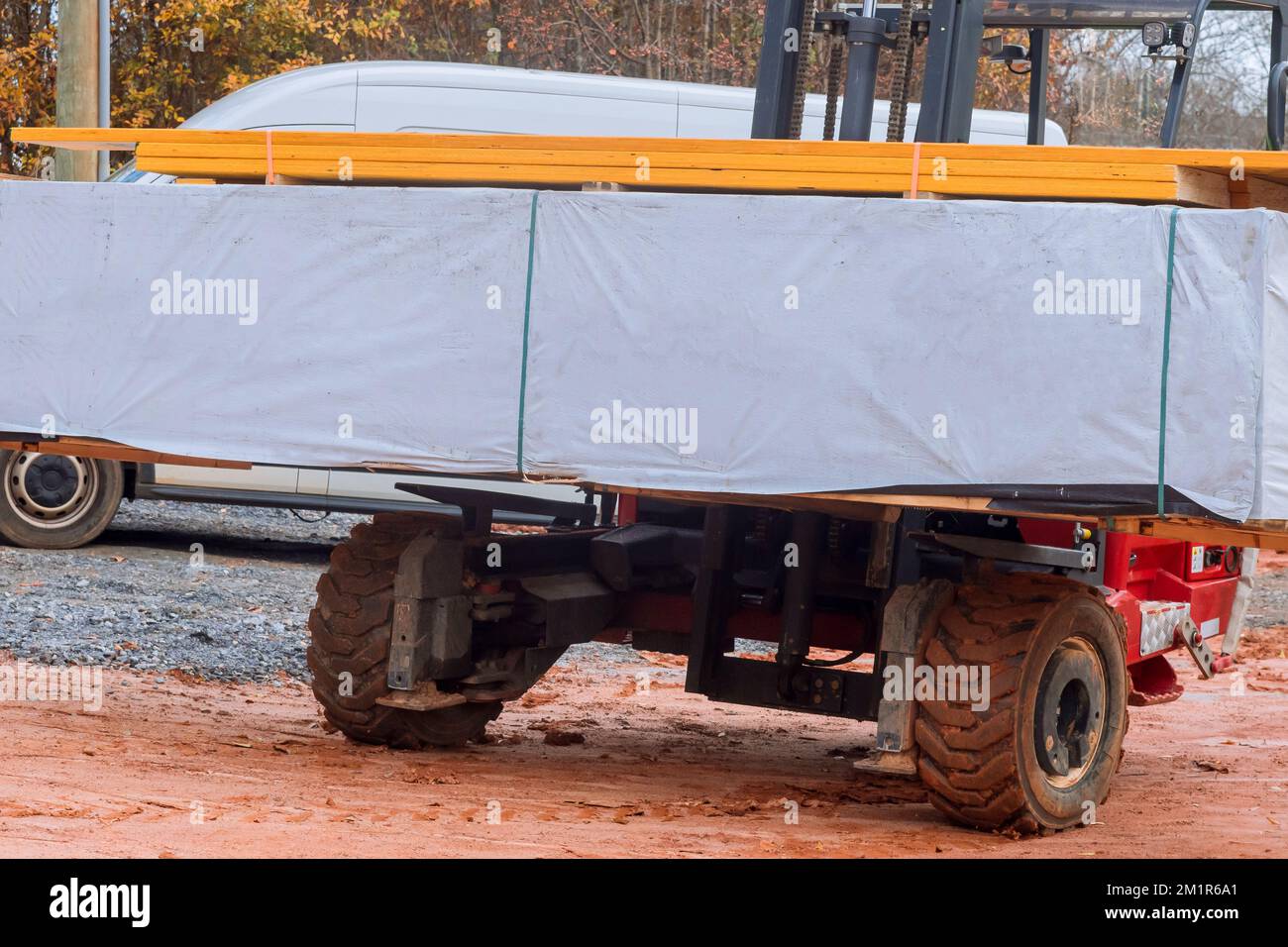 Les travaux de chariot élévateur déchargent les pièces de matériaux de construction Banque D'Images