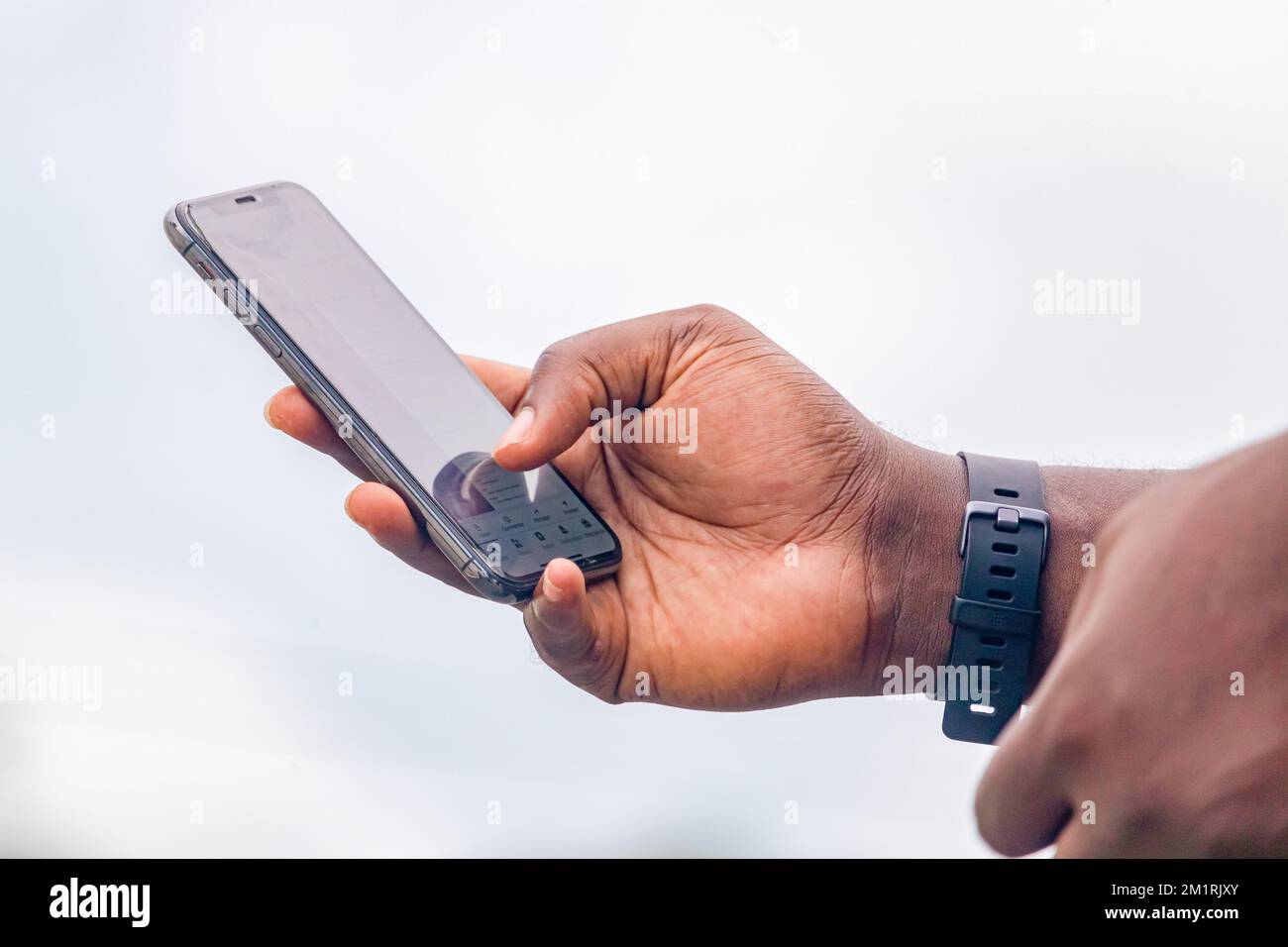 Homme africain de la main lisant le message texte sur le téléphone mobile en milieu urbain Banque D'Images