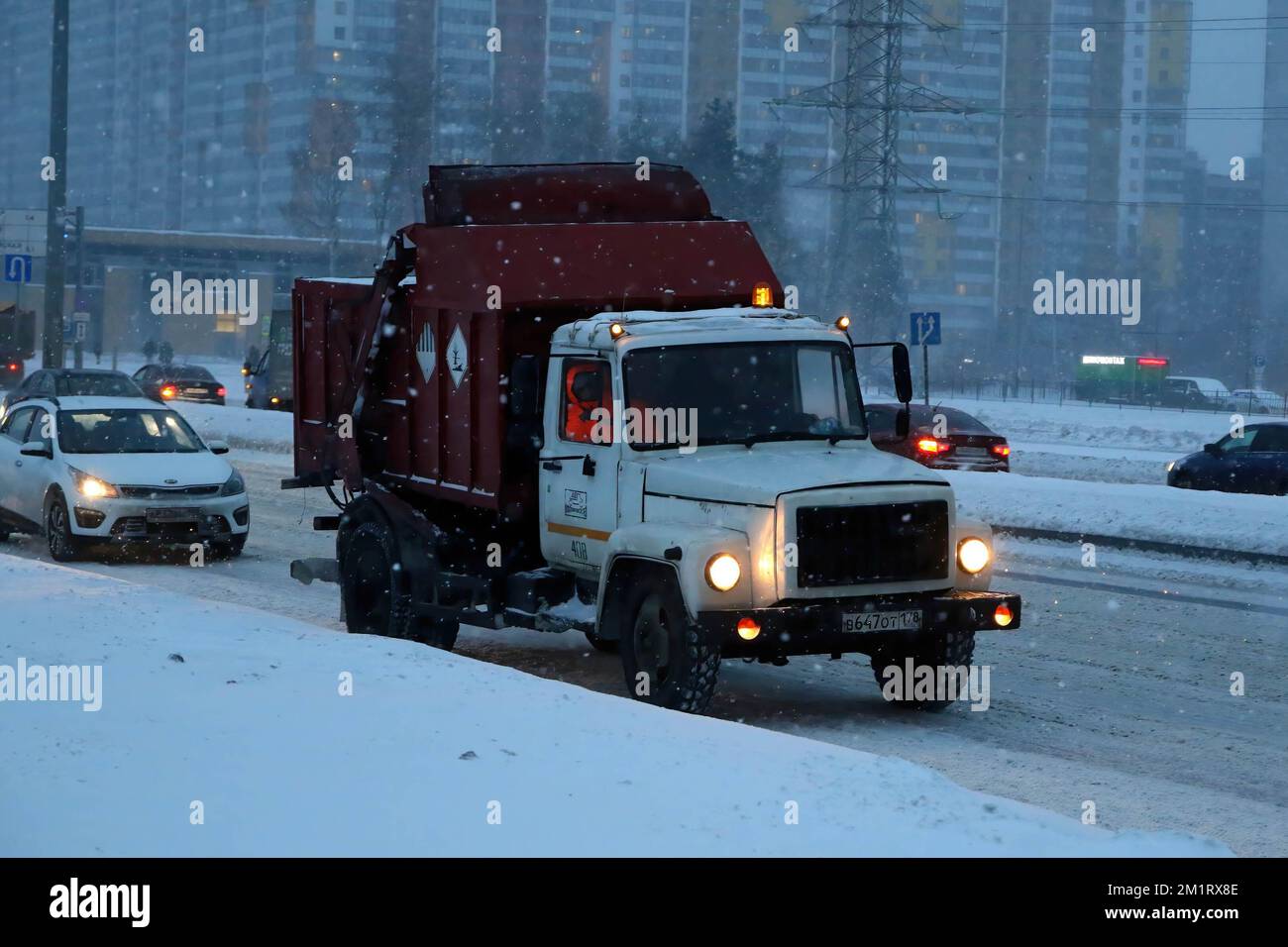 Un camion à ordures roule le long de la route pendant une forte chute ...