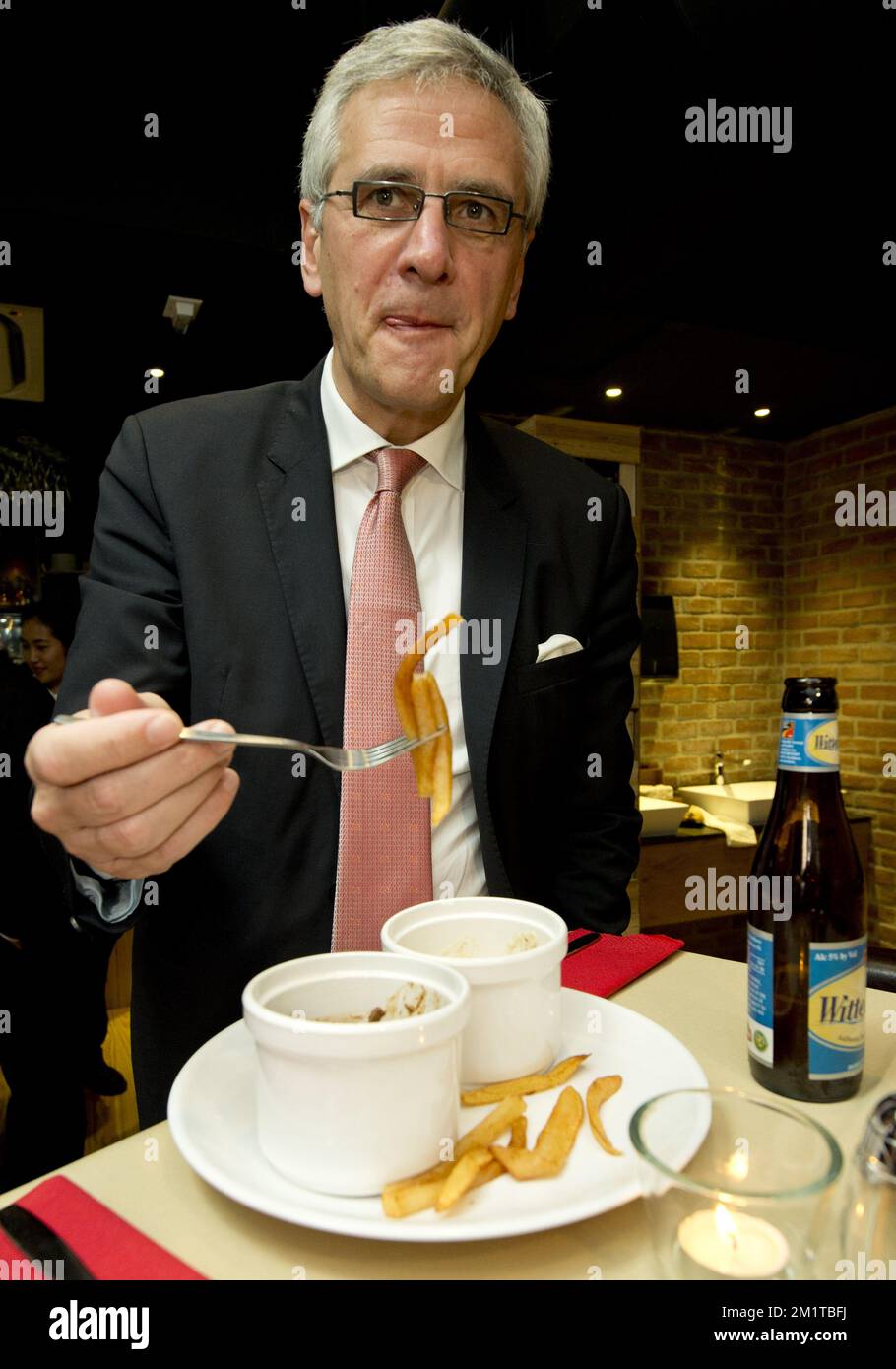 20131204 - HONG KONG, CHINE : le ministre-président flamand Kris Peeters mange des frites belges lors de la cérémonie d'ouverture du restaurant d'origine belge à Hong Kong le deuxième jour d'une mission économique à l'occasion de l'événement « Hong Kong Business of Design week (BoDW) » à Hong Kong, Région administrative spéciale de la République populaire de Chine, mercredi 04 décembre 2013. La reine Mathilde de Belgique est rejointe par les ministres des différentes régions pour la mission. BELGA PHOTO BENOIT DOPPAGNE Banque D'Images