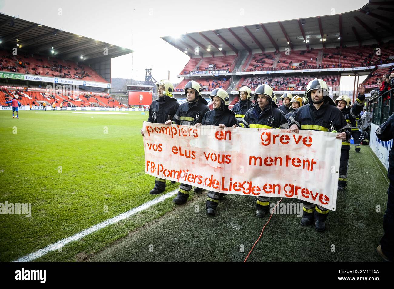 20131215 - LOUVAIN, BELGIQUE : l'illustration montre des pompiers en grève protestant sur le terrain avant le match Jupiler Pro League entre Standard de Liège et KRC Genk, à Liège, dimanche 15 décembre 2013, le dix-neuvième jour du championnat belge de football. BELGA PHOTO NICOLAS LAMBERT Banque D'Images