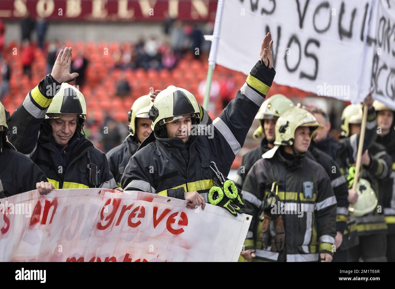 20131215 - LOUVAIN, BELGIQUE : l'illustration montre des pompiers en grève protestant sur le terrain avant le match Jupiler Pro League entre Standard de Liège et KRC Genk, à Liège, dimanche 15 décembre 2013, le dix-neuvième jour du championnat belge de football. BELGA PHOTO NICOLAS LAMBERT Banque D'Images