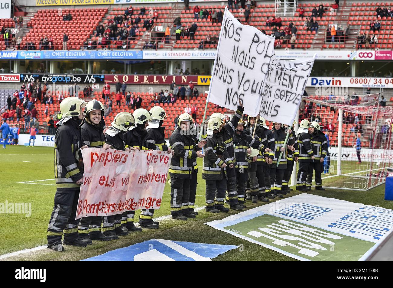 20131215 - LOUVAIN, BELGIQUE : l'illustration montre des pompiers en grève protestant sur le terrain avant le match Jupiler Pro League entre Standard de Liège et KRC Genk, à Liège, dimanche 15 décembre 2013, le dix-neuvième jour du championnat belge de football. BELGA PHOTO NICOLAS LAMBERT Banque D'Images