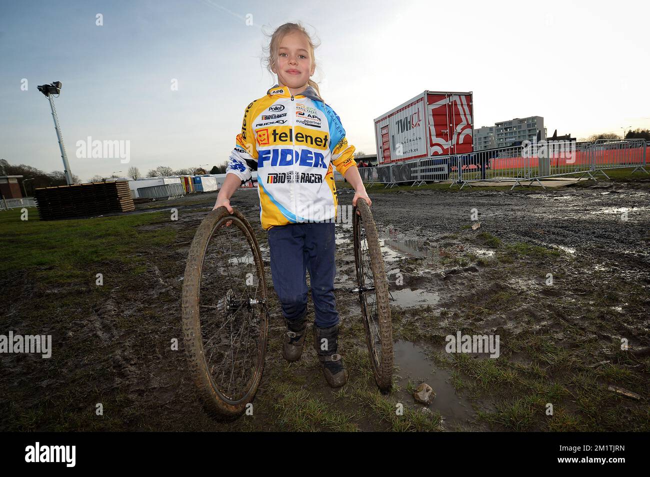 20140108 - WAREGEM, BELGIQUE: Illustration montre une fille dans un maillot Telenet Fidea tenant deux pneus sur la piste des prochains championnats nationaux belges cyclocross, mercredi 08 janvier 2014 à Waregem. Le championnat aura lieu dimanche. BELGA PHOTO DAVID STOCKMAN Banque D'Images