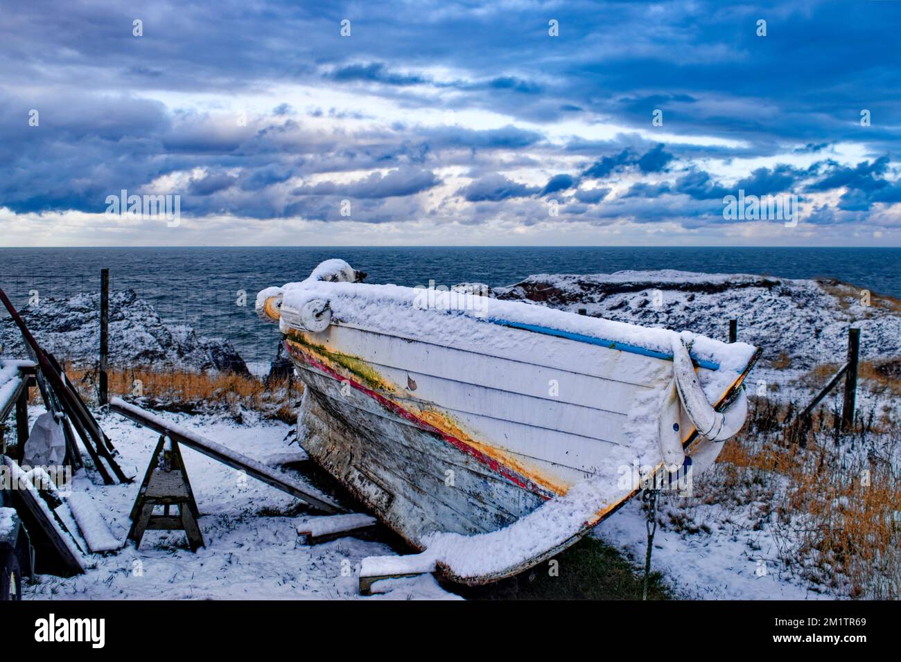 Petit bateau de pêche en hiver recouvert de neige Banque D'Images