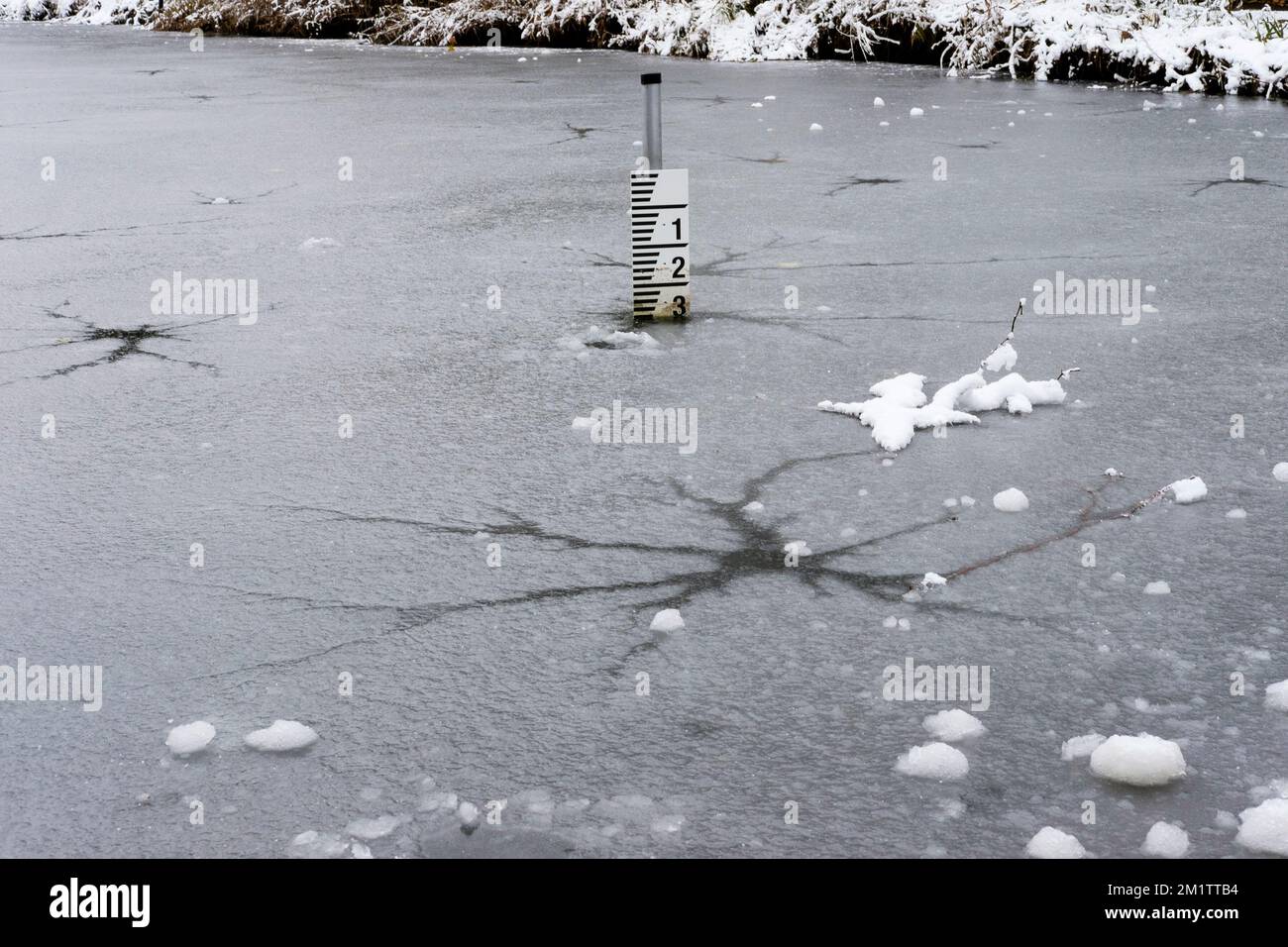 Glace fine et fissurée sur l'étang gelé. ROYAUME-UNI Banque D'Images