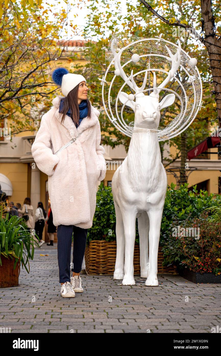 Femme à côté d'un cerf blanc à Noël Banque D'Images