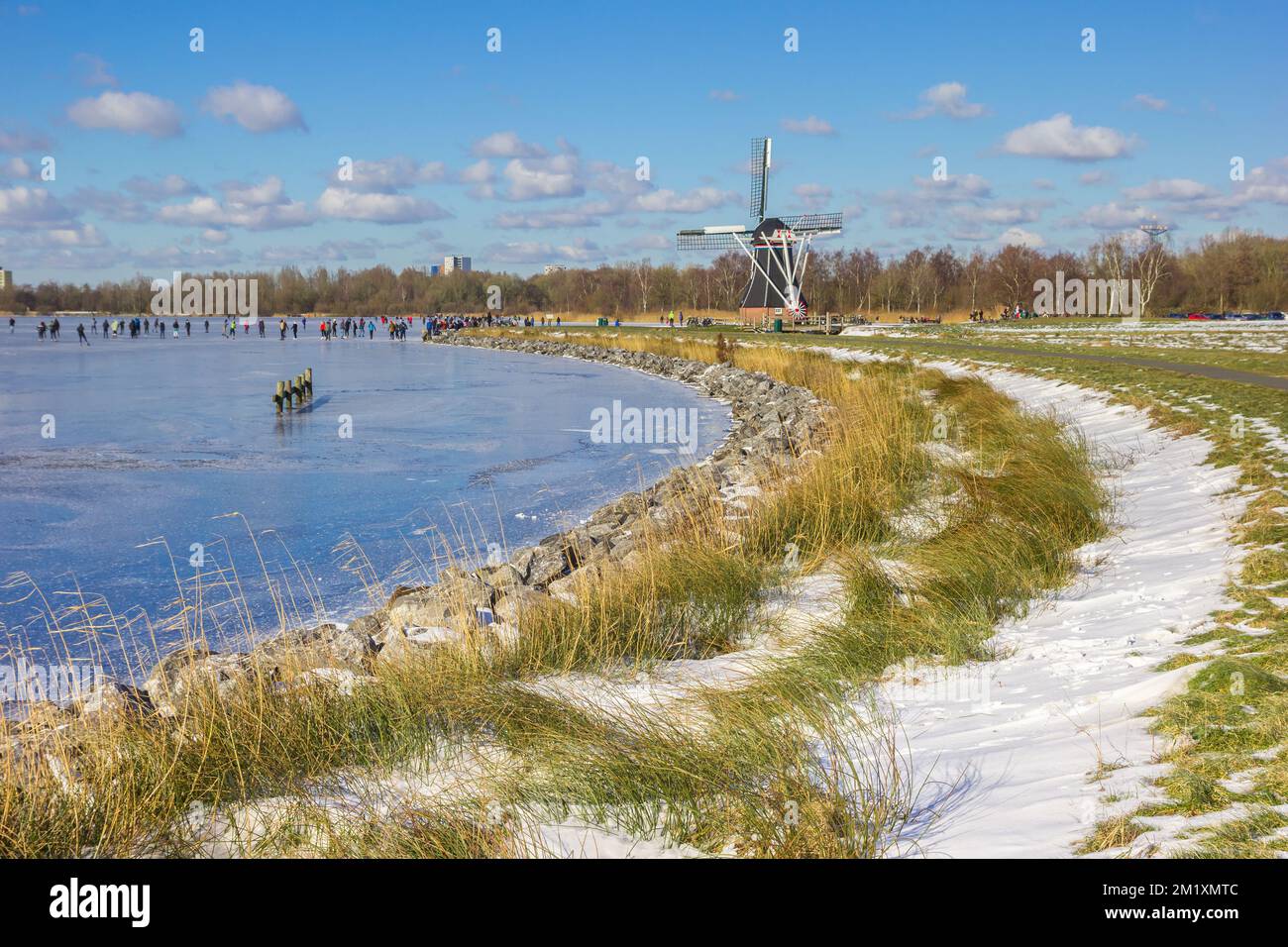Moulin à vent historique sur le lac gelé à Paterswolde, pays-Bas Banque D'Images
