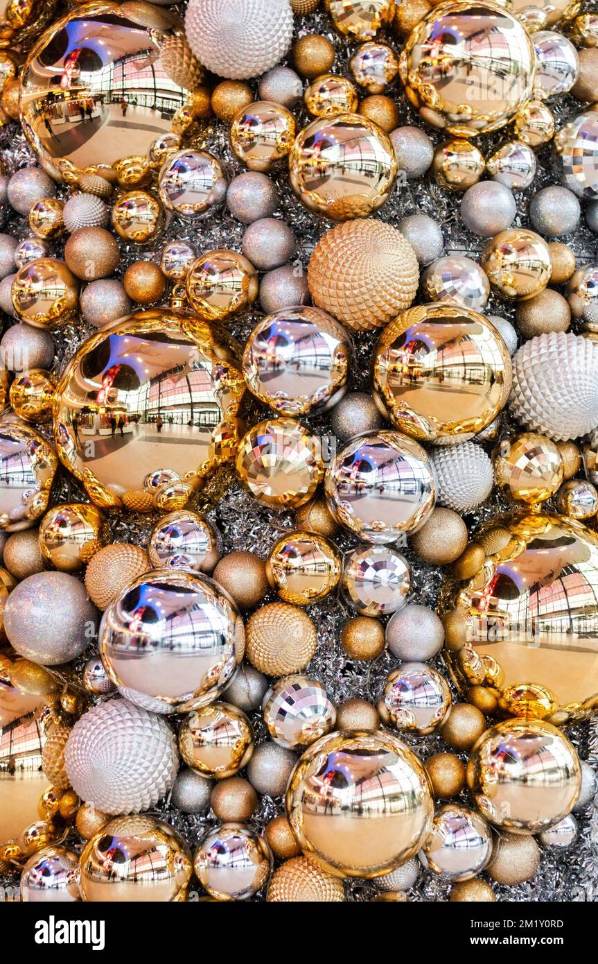 Un gros plan vertical de boules blanches et dorées de Noël de différentes tailles Banque D'Images