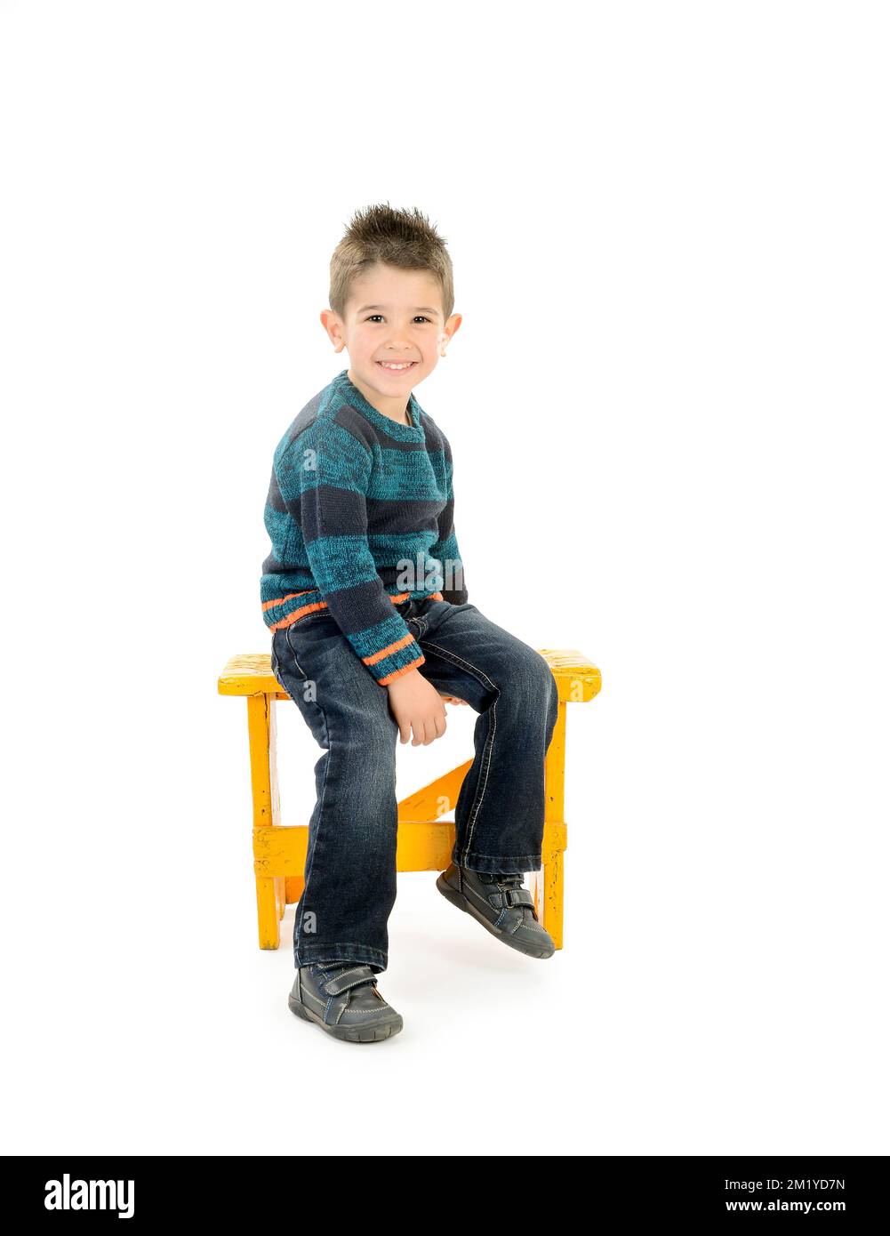 Enfant isolé souriant assis dans un siège jaune Banque D'Images