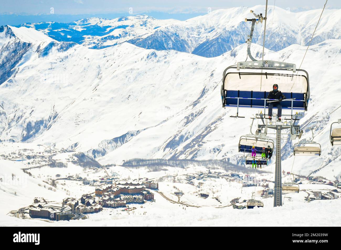 25th janvier 2022 - Gudauri, Géorgie : instructeur de skieur assis sur la remontée mécanique et avec la nouvelle station de ski de Gudauri et le fond des montagnes Banque D'Images