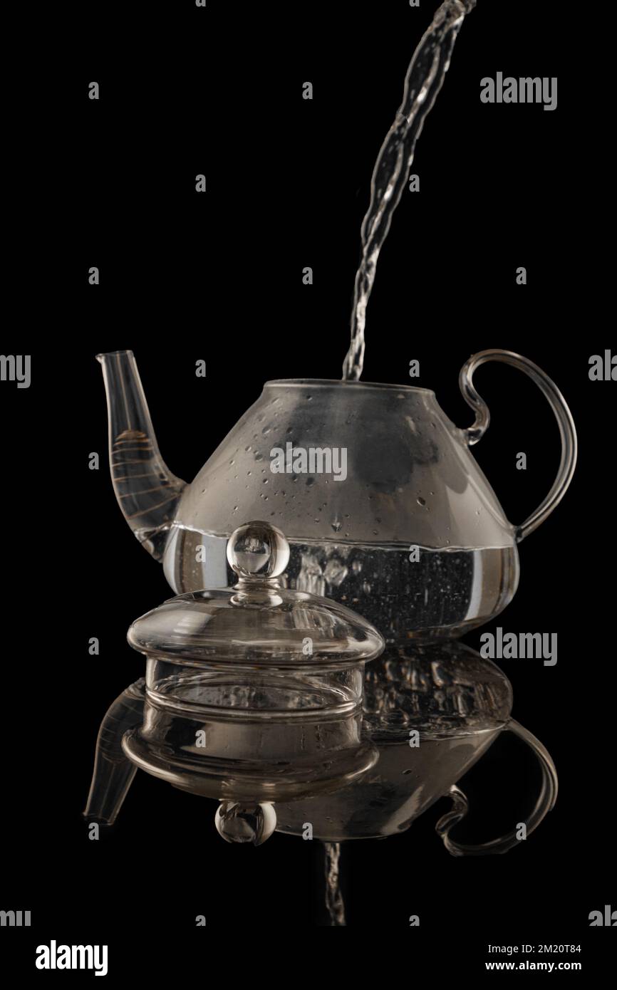 Magnifique théière en verre transparent isolée sur fond noir Banque D'Images