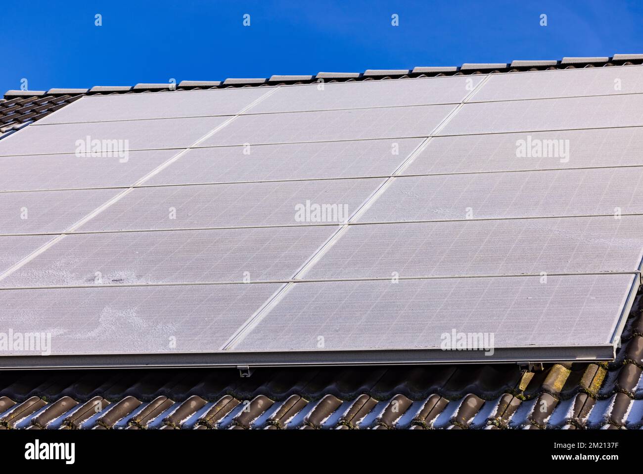 Les panneaux solaires gelés d'un système photovoltaïque sur le toit d'une maison en hiver ne produisent pas d'énergie Banque D'Images
