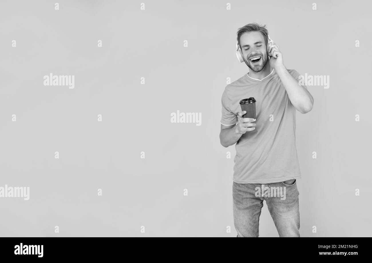 de retour à l'école. un jeune homme dans un casque boit du café. un mélomane. écoutez de la musique. Banque D'Images