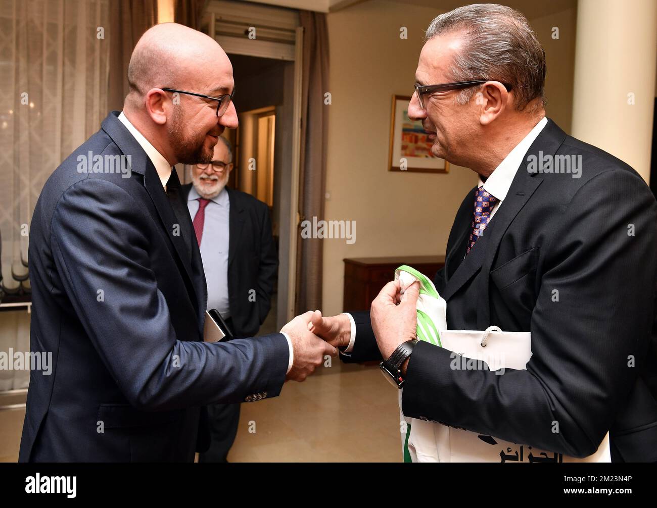 Le Premier ministre belge Charles Michel reçoit un maillot de football avec son nom de l'équipe nationale algérienne des mains de l'entraîneur de football Georges Leekens lors d'une réception à l'ambassade de Belgique à Alger, le deuxième jour de la visite du Benelux à l'après-midi, le mardi 06 décembre 2016, en Algérie. BELGA PHOTO ERIC LALMAND Banque D'Images