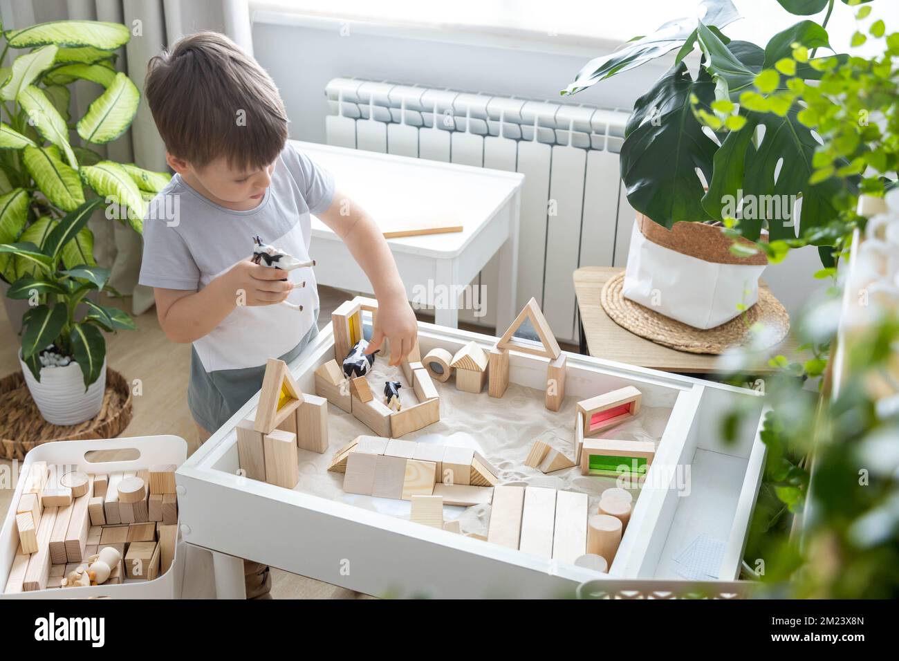 Mignon garçon enfant jouant sensoriel boîte cinétique table de sable ...