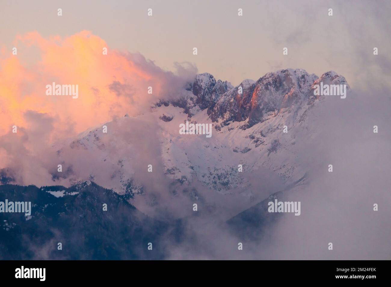 Vue sur la montagne Presolana entre les nuages sur un coucher de soleil d'hiver. Val Seriana, Castione della Presolana, Bergame district, Lombardie, Italie. Banque D'Images