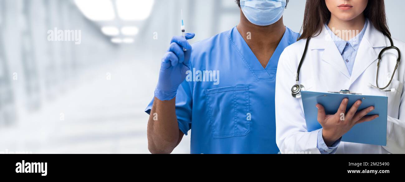 Bannière médicale. Deux médecins multiethniques portant un uniforme posant sur l'arrière-plan de la salle d'hôpital Banque D'Images