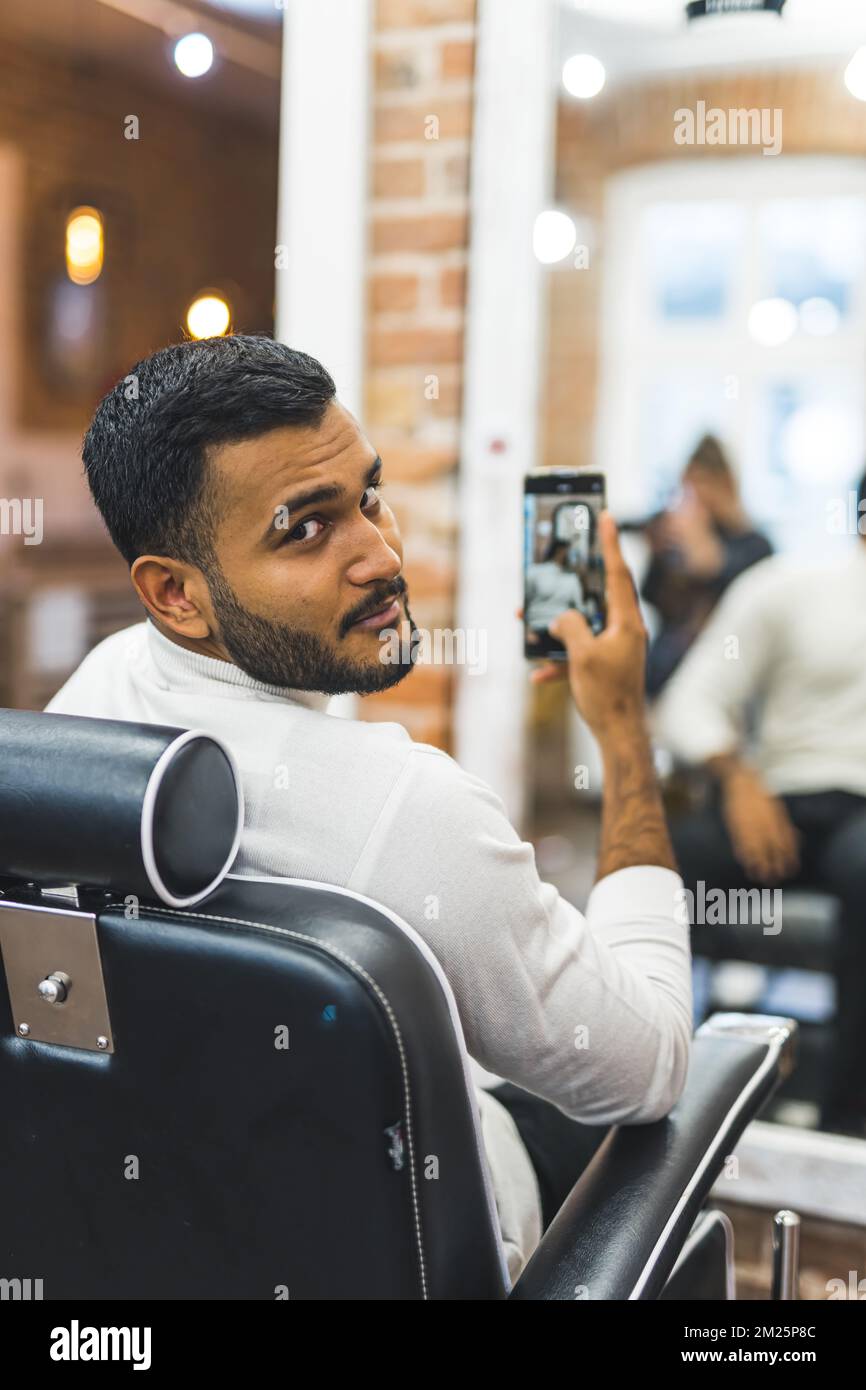 Jeune homme prenant le miroir selfie après avoir eu ses cheveux coupés à la  barbershop. Photo de haute qualité Photo Stock - Alamy