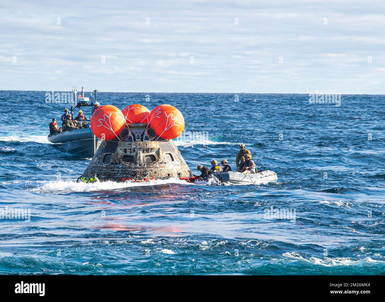 Océan Pacifique. 12th décembre 2022. Des plongeurs de la Marine affectés à l'élimination de l'artillerie de combat de la Force expéditionnaire de la Marine (EODESU) 1 relient l'ensemble du mécanisme d'atténuation de charge de la ligne de la NASA à l'engin spatial Artemis I Orion de la NASA pour le tirer dans le pont de puits du quai de transport amphibie USS Portland (LPD 27), le 11 décembre 2022. Portland et le navire de combat littoral Independence-variant USS Montgomery (LCS 8) sont en cours dans la flotte américaine 3rd à l'appui de la récupération. L'opération de récupération fait partie d'un effort du ministère de la Défense qui intègre le commandement du combattant Banque D'Images