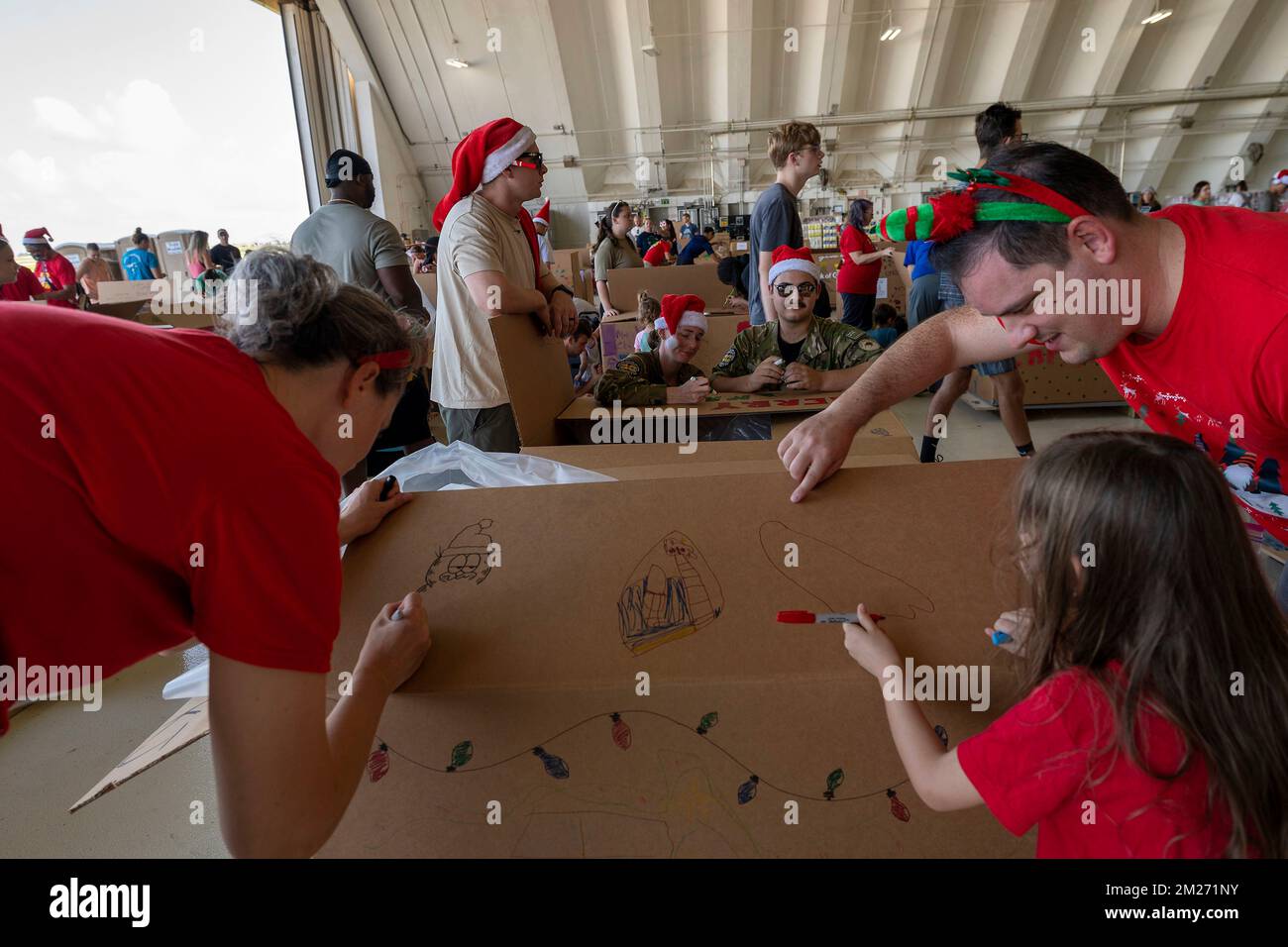 Yigo, États-Unis. 03 décembre 2022. Des bénévoles décorent les boîtes de paquets en vue de leur livraison durant l'opération Christmas Drop 2022 à la base aérienne d'Andersen, à 3 décembre 2022, à Yigo, à Guam. L'opération Christmas Drop est la plus ancienne mission humanitaire et de secours en cas de catastrophe qui livre 71 000 livres de nourriture, de cadeaux et de fournitures pour aider les communautés insulaires éloignées du Pacifique Sud. Crédit : Yasuo Osakabe/US Airforce photo/Alay Live News Banque D'Images
