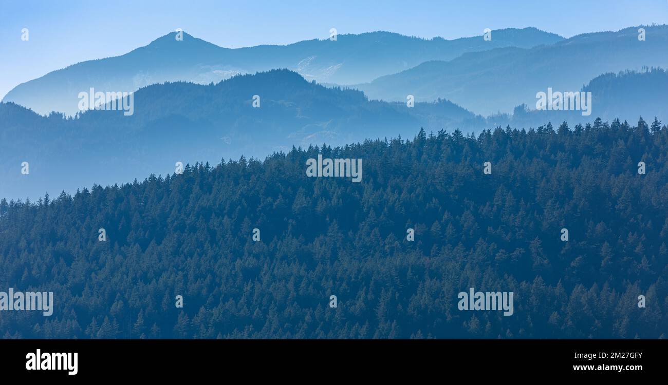 Couches de montagne. Smoky Layers on Layers à la fin de l'automne. Chaîne de montagnes avec silhouettes visibles dans le brouillard du matin Banque D'Images