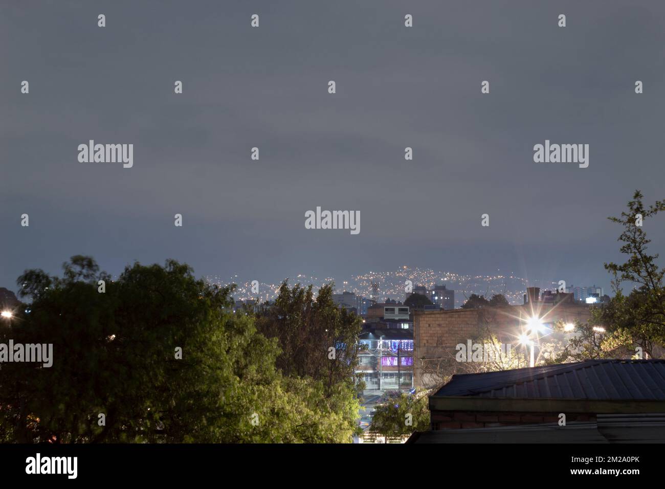 Une vue typique depuis le toit à l'extérieur des banlieues quartier lumières de nuit dans la ville d'amérique latine avec ciel gris nuageux Banque D'Images