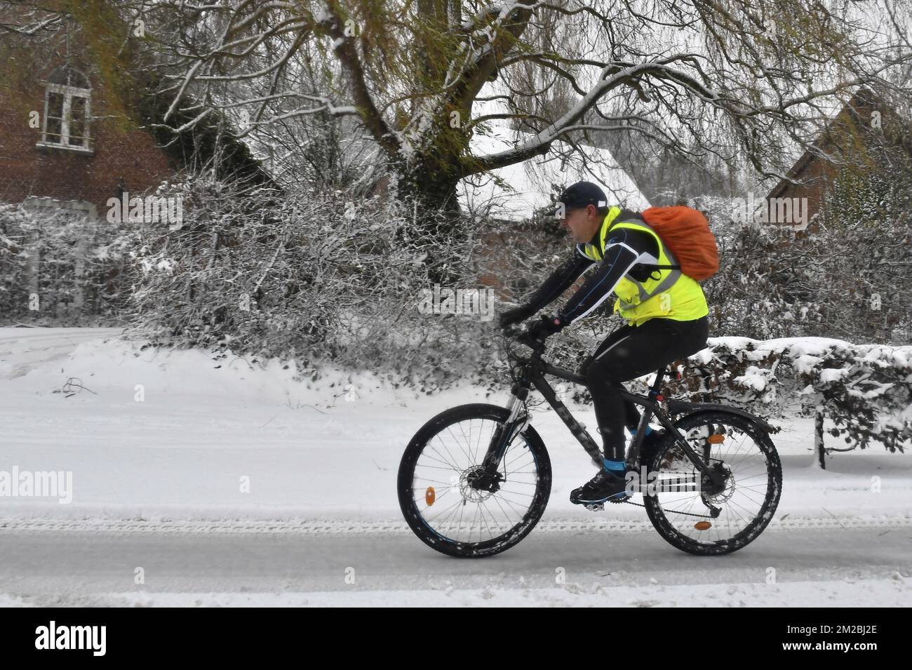 L'illustration montre un cycliste avec gilet jaune fluorescent à cheval sur  un VTT à travers la neige alors que les températures froides balayent la  Belgique, lundi 11 décembre 2017. BELGA PHOTO DIRK
