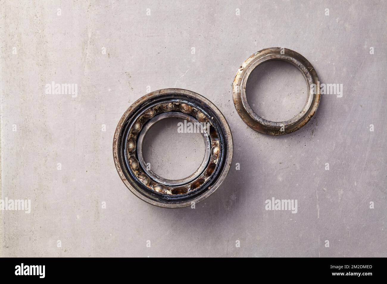 Un roulement de roue usagé sale sur sol gris Banque D'Images