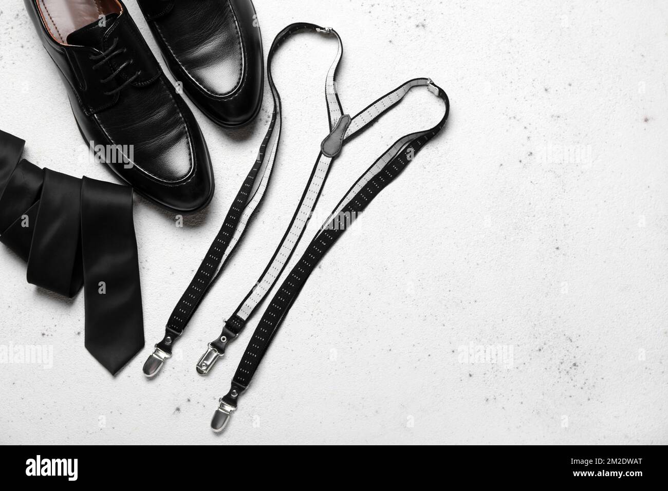 Chaussures, bretelles et cravates en cuir sur fond léger Banque D'Images