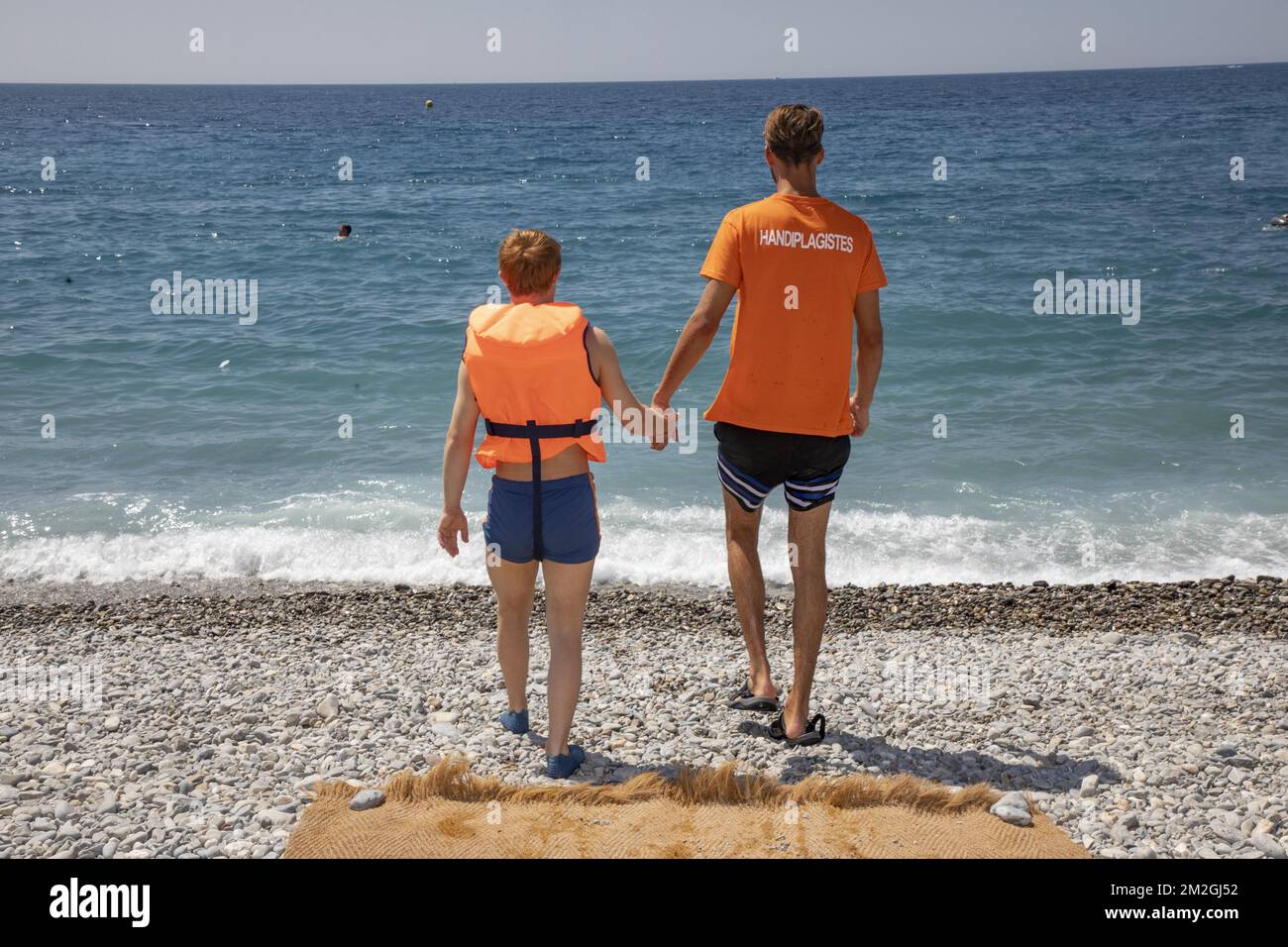 Présentation par Christian Estrosi, Maire de Nice, du programme d'été 2018 pour l'accueil des personnes à mobilité réduite et la sécurité des plages de Nice. Sur la photo secouristes accompagnant une personne handicapée| Présentation par Christian Estrosi, Maire de Nice, du positif estival 2018, pour l'accueil des personnes à mobilité réduite et de la sécurité des plages de Nice . Sur la photo un compagnon d'action une personne handicapée. 06/07/2018 Banque D'Images