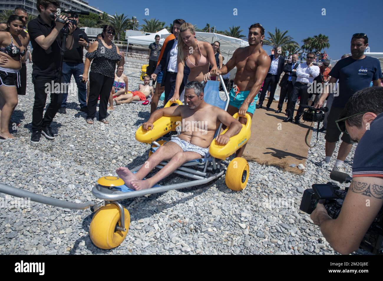 Présentation par Christian Estrosi, Maire de Nice, du programme d'été 2018 pour l'accueil des personnes à mobilité réduite et la sécurité des plages de Nice.sur la photo démonstration d'un fauteuil roulant de plage pour les handicapés par les sauveteurs. | Présentation par Christian Estrosi, Maire de Nice, du programme estival 2018, pour l'accueil des personnes à mobilité et de la sécurité des plages de Nice . Sur la photo démonstration d un fauteuil roulant de plage pour les handicaps par les sauteurs. 06/07/2018 Banque D'Images