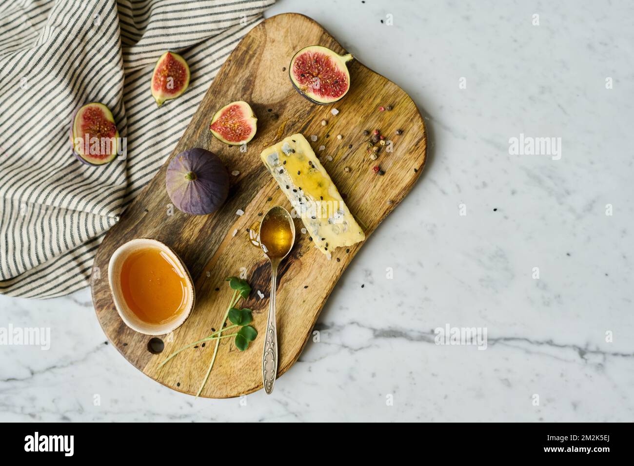 Vue panoramique sur un plateau en bois avec fruits exotiques et fromage servis avec du miel Banque D'Images