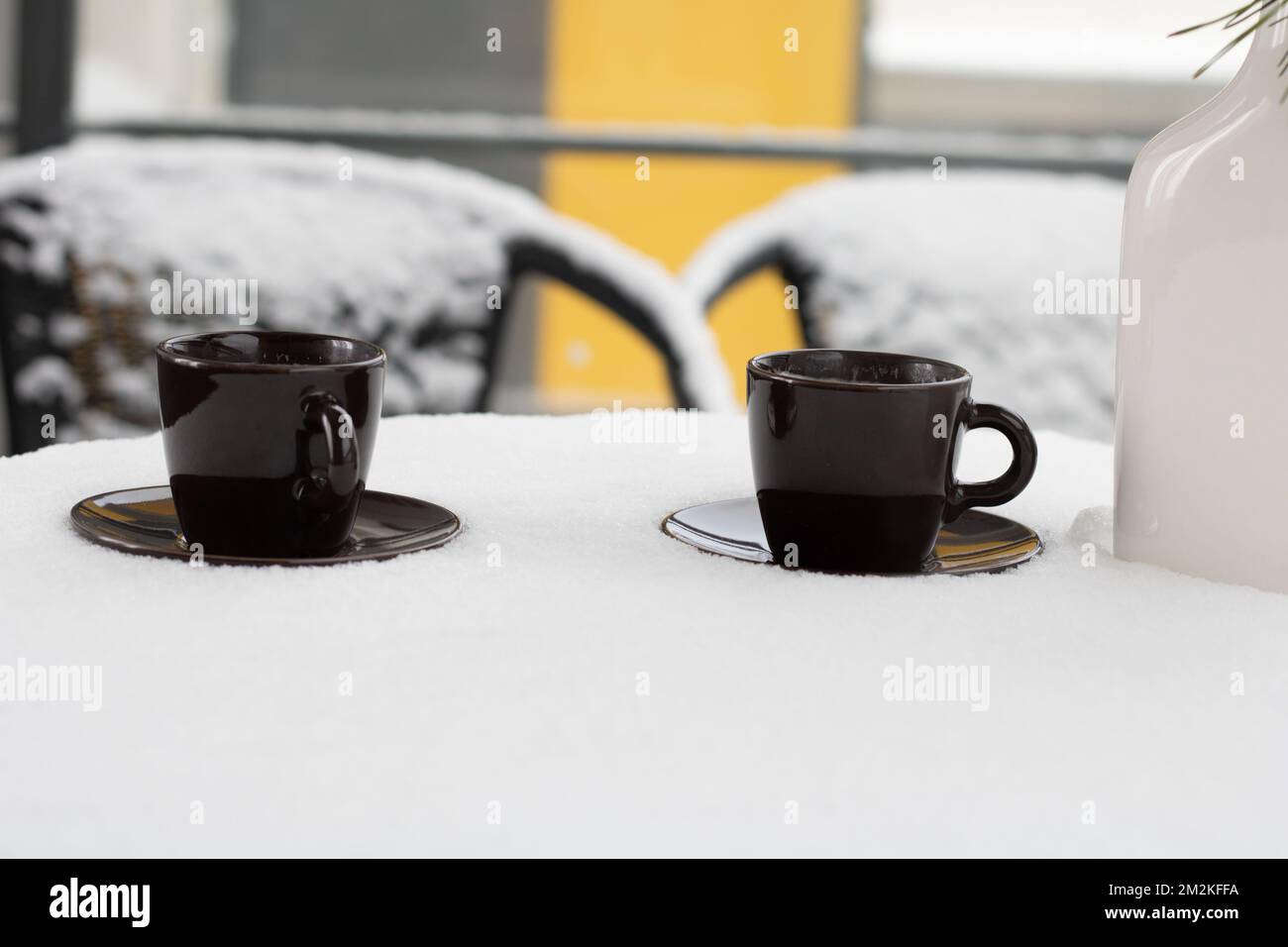 photo sur une table recouverte de neige il y a des tasses de café sur les soucoupes Banque D'Images