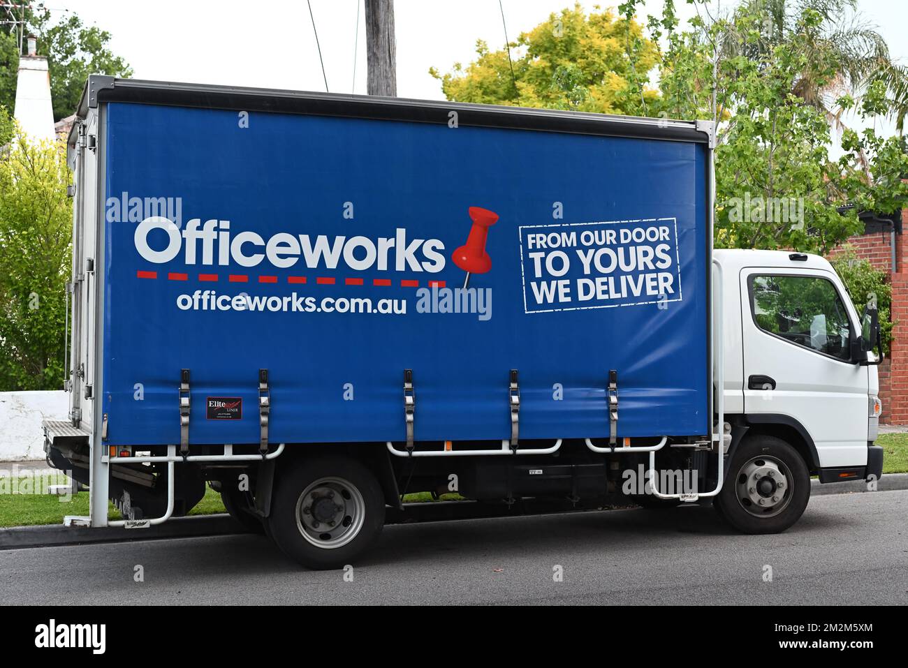 Vue latérale d'un camion de livraison d'Officeworks, garé à l'extérieur d'une maison dans une rue de banlieue de Melbourne Banque D'Images