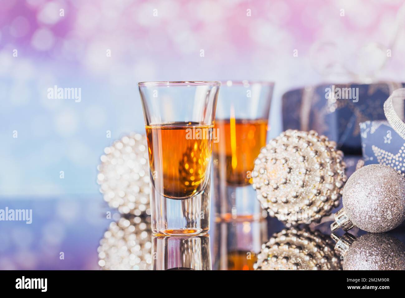Deux verres de whisky ou de bourbon avec décoration de Noël sur fond de bokeh léger. Le concept d'ambiance Whiskey pour les fêtes de nouvel an, de Noël et d'hiver Banque D'Images