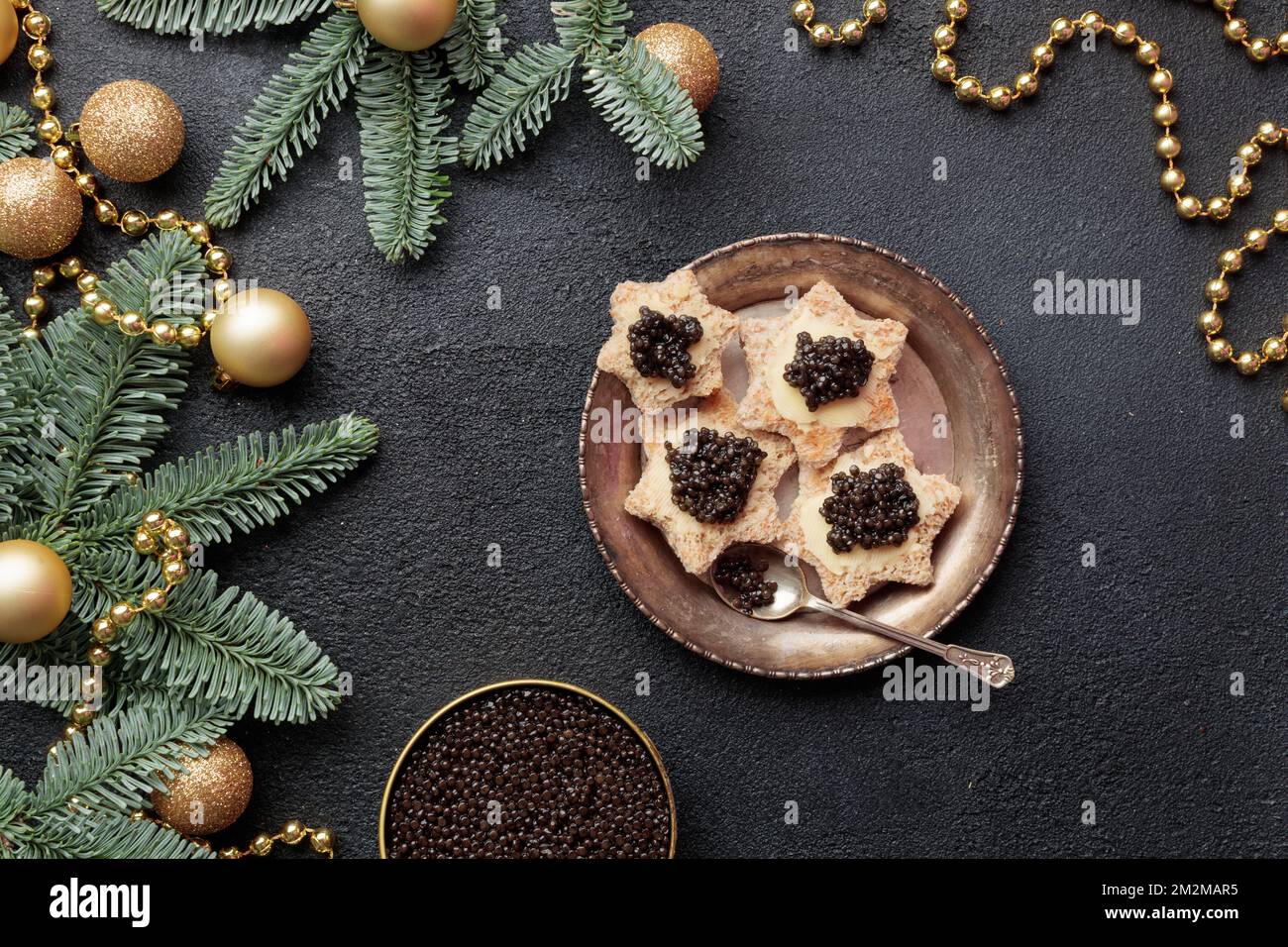 Caviar noir hors-d'œuvre étoiles sur une table noire décorée de noël horizontale Banque D'Images