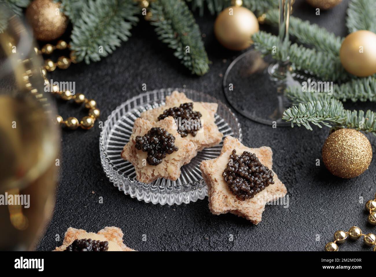Caviar noir hors-d'œuvre étoiles sur une table noire décorée de noël horizontale Banque D'Images