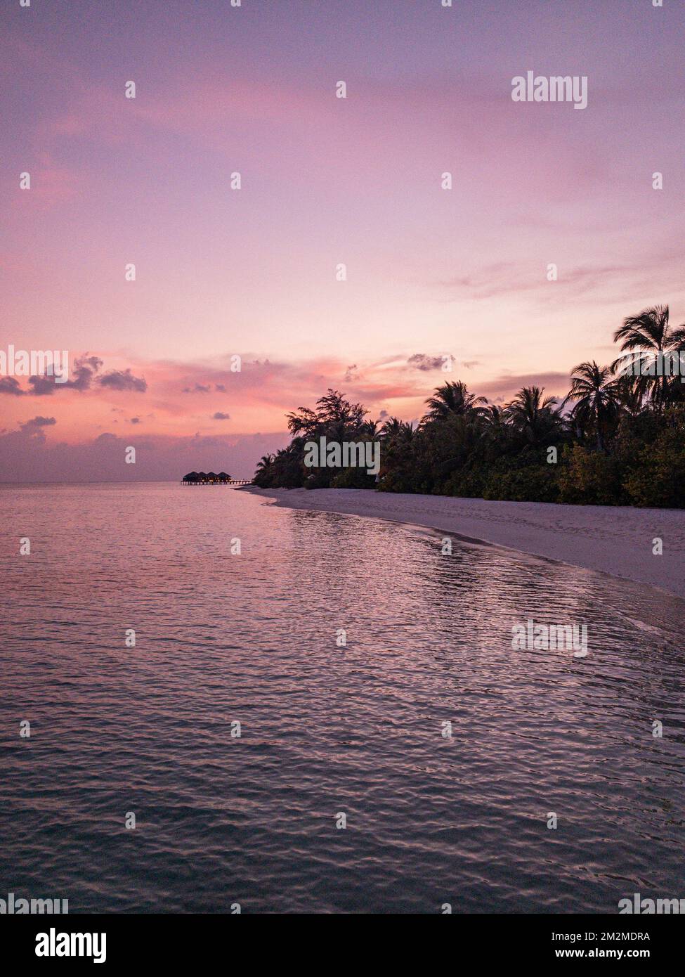 Fantastique vue tranquille de près des vagues d'eau de mer calmes avec lumière du soleil orangée au lever du soleil. Paysage tropical de plage d'île, côte exotique de rivage Banque D'Images