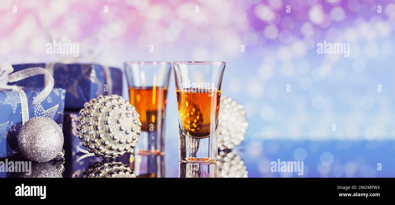 Deux verres de whisky ou de bourbon avec décoration de Noël sur fond de bokeh léger. Le concept d'ambiance Whiskey pour les fêtes de nouvel an, de Noël et d'hiver Banque D'Images